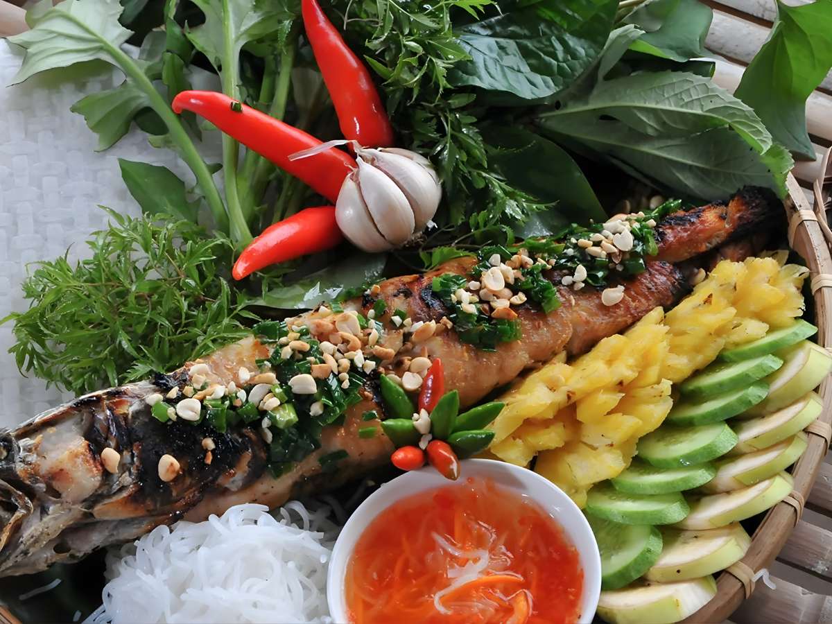 Món cá lóc nướng trui bày biện hài hòa cùng rau và bánh tráng để thưởng thức trọn vẹn hương vị. 