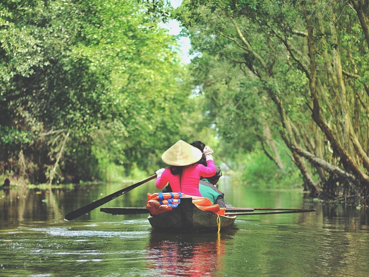 Du khách trèo thuyền xuyên rừng tràm tại khu du lịch sinh thái Gáo Giồng.