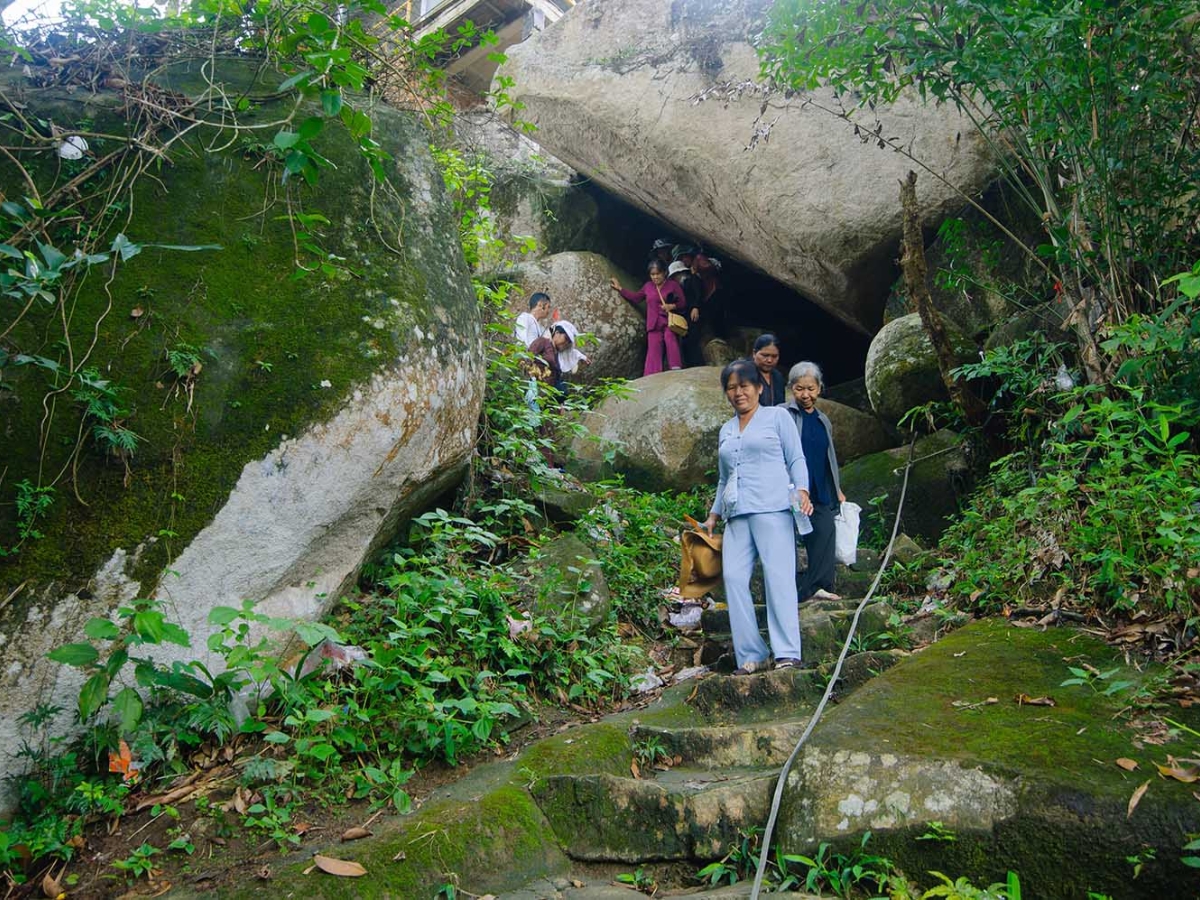 Du khách khám phá hang động tại núi Cấm. 