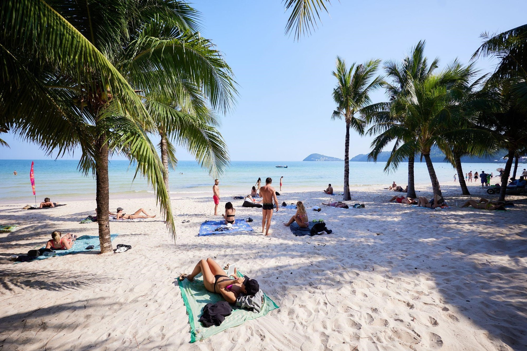 Tourists sunbathe and relax at Kem Beach.