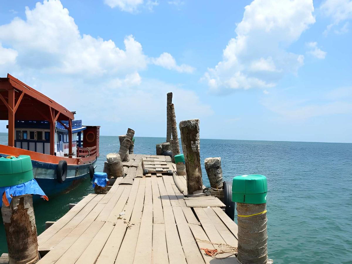 Cầu gỗ dài vươn ra biển xanh tại làng chài Hàm Ninh cổ.