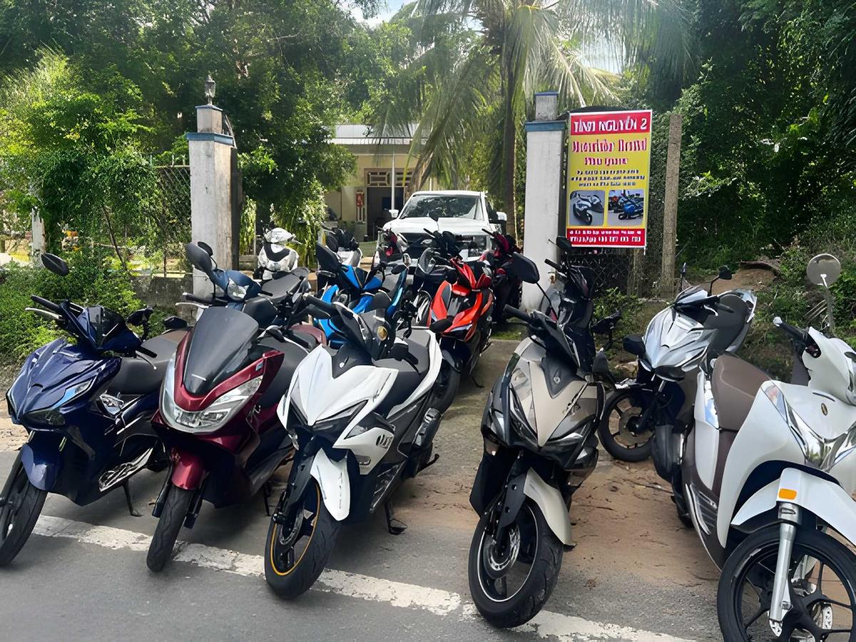 Du khách lái xe máy trên đường nhựa dẫn vào làng chài Hàm Ninh.