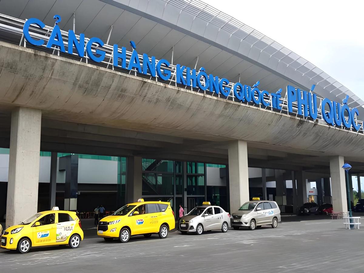 Taxi and ride-hailing vehicles waiting for passengers in the airport arrivals area.