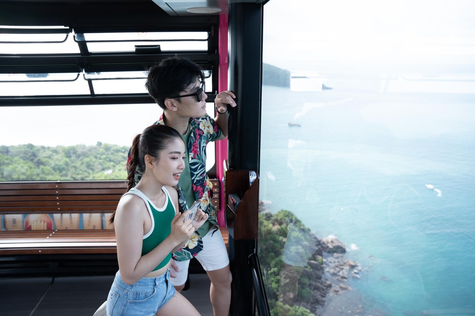 Du khách chiêm ngưỡng cảnh biển đảo hùng vĩ từ cabin cáp treo. 